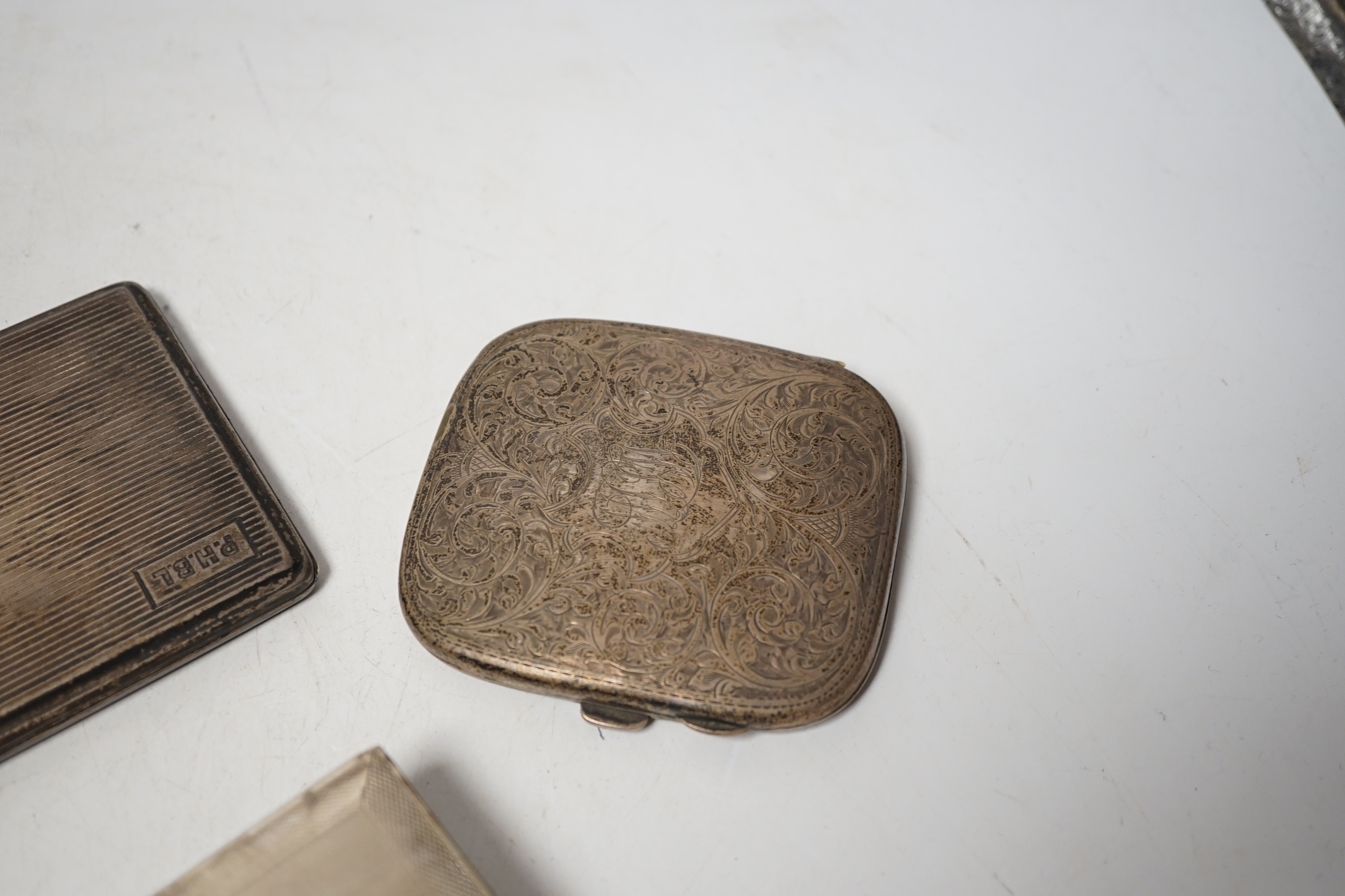 A 1930's engine turned silver cigarette box, 16.6cm, an Edwardian silver cigarette box and two silver cigarette cases.